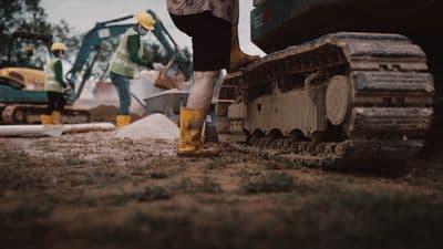 a man standing next to a bulldozer on top of a field