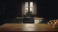 a kitchen with a stove and a table with fruit on it