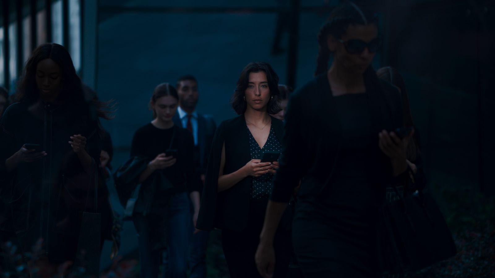 a group of people walking down a street at night
