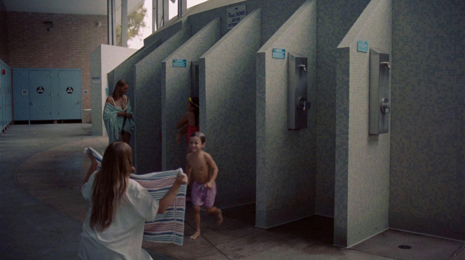a group of people standing around a bathroom stall
