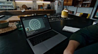 a person sitting at a table with a laptop