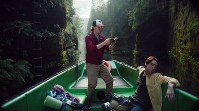 a man taking a picture of another man in a boat
