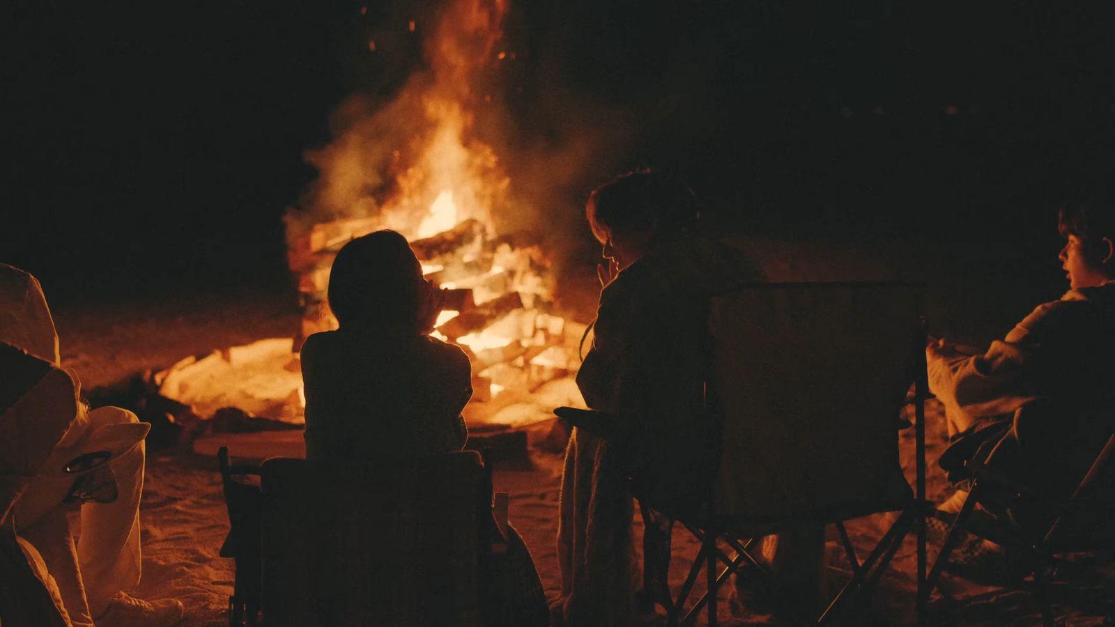 a group of people sitting around a fire pit