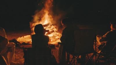 a group of people sitting around a fire pit