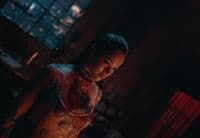 a woman with tattoos standing in a dark room