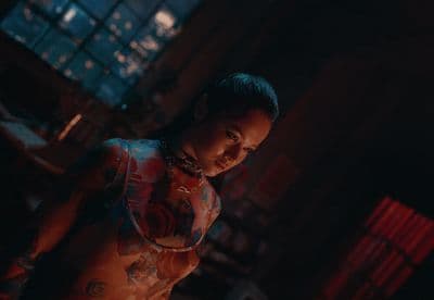 a woman with tattoos standing in a dark room