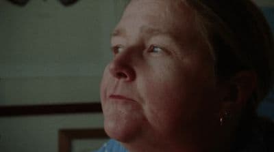 a woman with blue eyes looking off into the distance