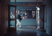 a man walking into a building through a glass door