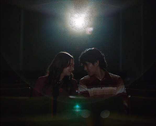 a man and a woman standing in a dark room