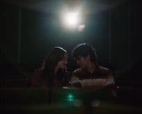 a man and a woman standing in a dark room
