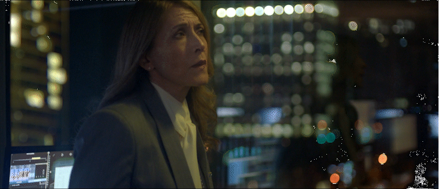 a woman standing in front of a window at night