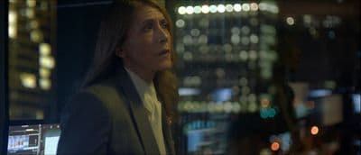 a woman standing in front of a window at night
