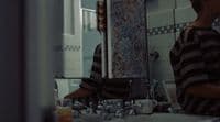 a young boy standing in front of a bathroom mirror