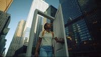 a woman standing in a doorway in a city
