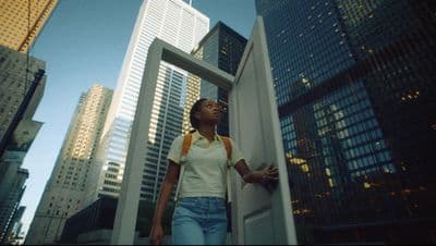 a woman standing in a doorway in a city