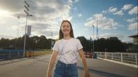 a woman in a white shirt is skateboarding