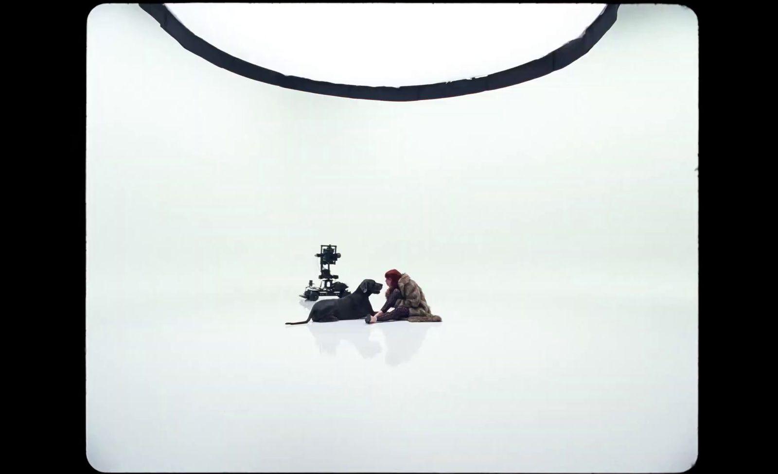 a man and a woman sitting on the ground in front of a camera