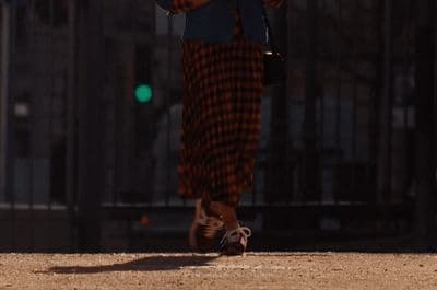 a woman walking down a street holding an umbrella