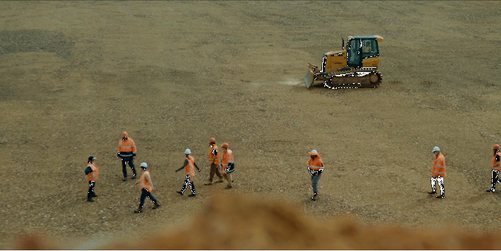 a group of people walking across a dirt field