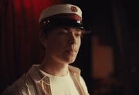 a man wearing a hat in a dark room