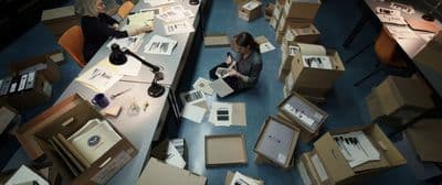 a woman sitting on the floor surrounded by boxes