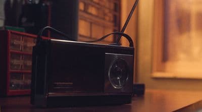 a black radio sitting on top of a wooden table