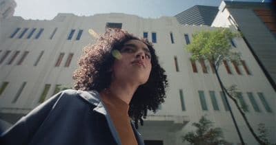 a woman standing in front of a tall building