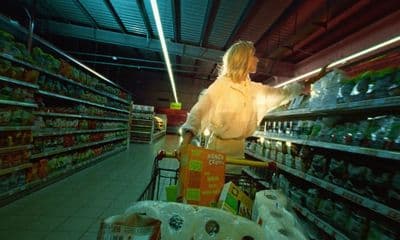 a woman pushing a shopping cart in a grocery store