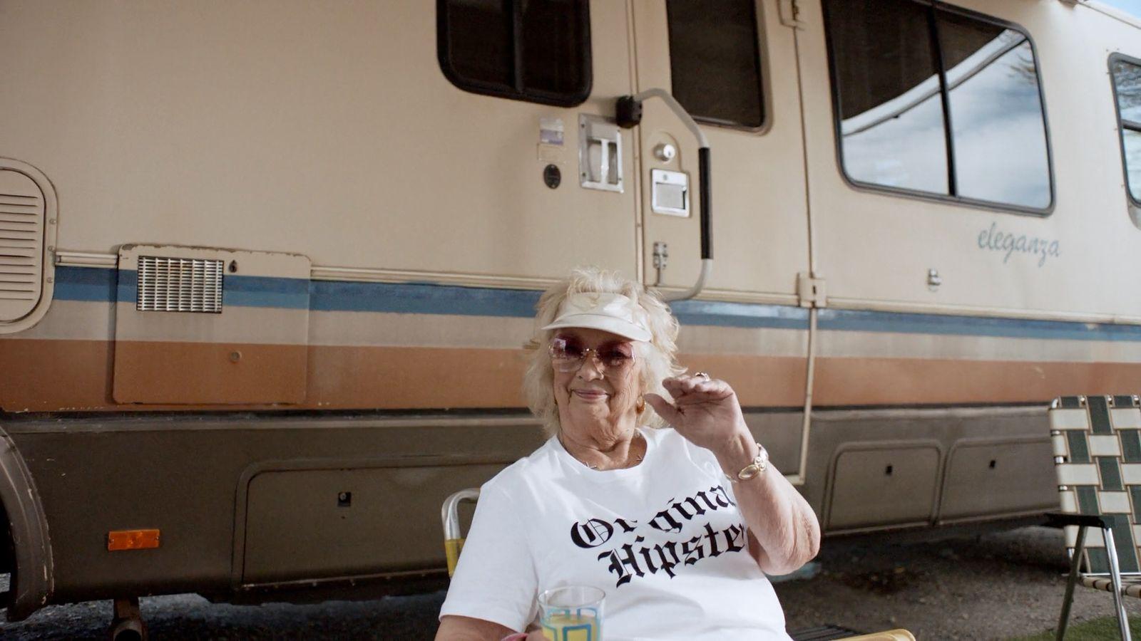 a woman sitting in a chair in front of a train