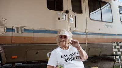 a woman sitting in a chair in front of a train