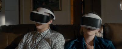 two women wearing virtual headsets sitting on a couch
