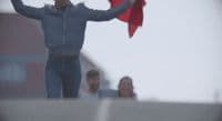 a man holding a red kite in the air