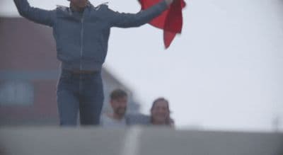 a man holding a red kite in the air