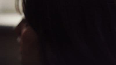 a close up of a person's hair with a cell phone in the background