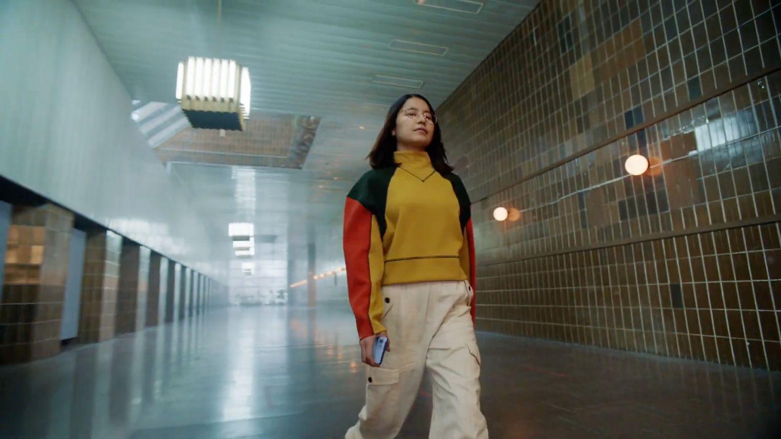 a woman standing in a hallway holding a tennis racquet