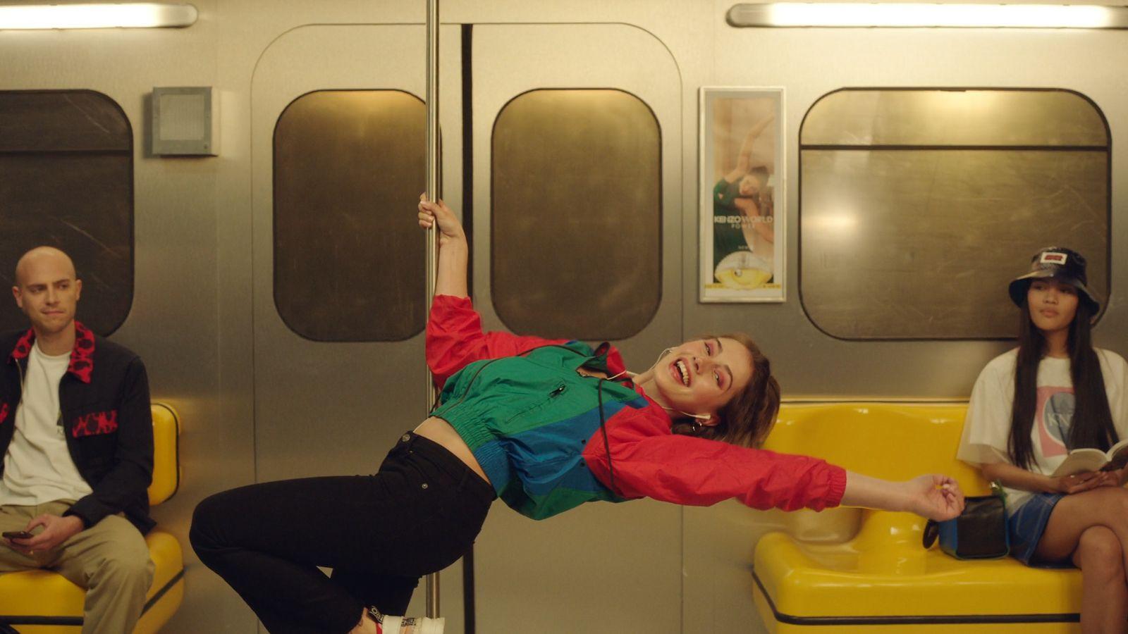 a woman in a red and green shirt is on a yellow bench
