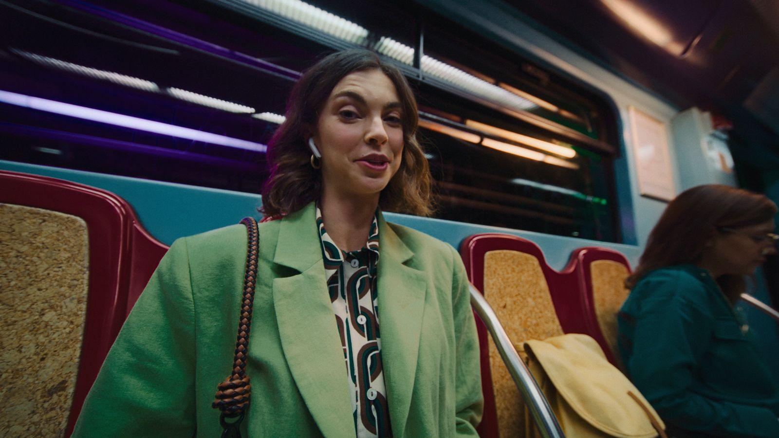 a woman in a green coat sitting on a bus