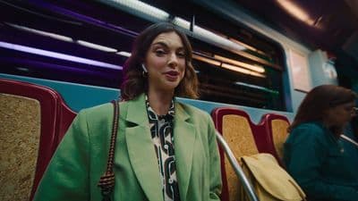 a woman in a green coat sitting on a bus