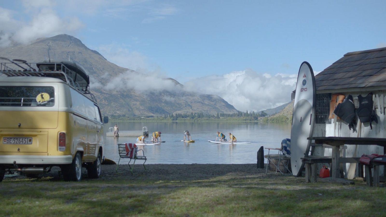 a group of people riding surfboards on top of a body of water