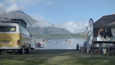 a group of people riding surfboards on top of a body of water