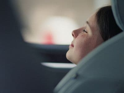 a woman sitting in a car looking out the window
