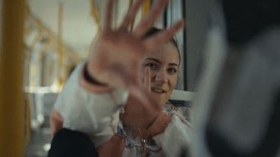 a woman making a hand gesture on a bus