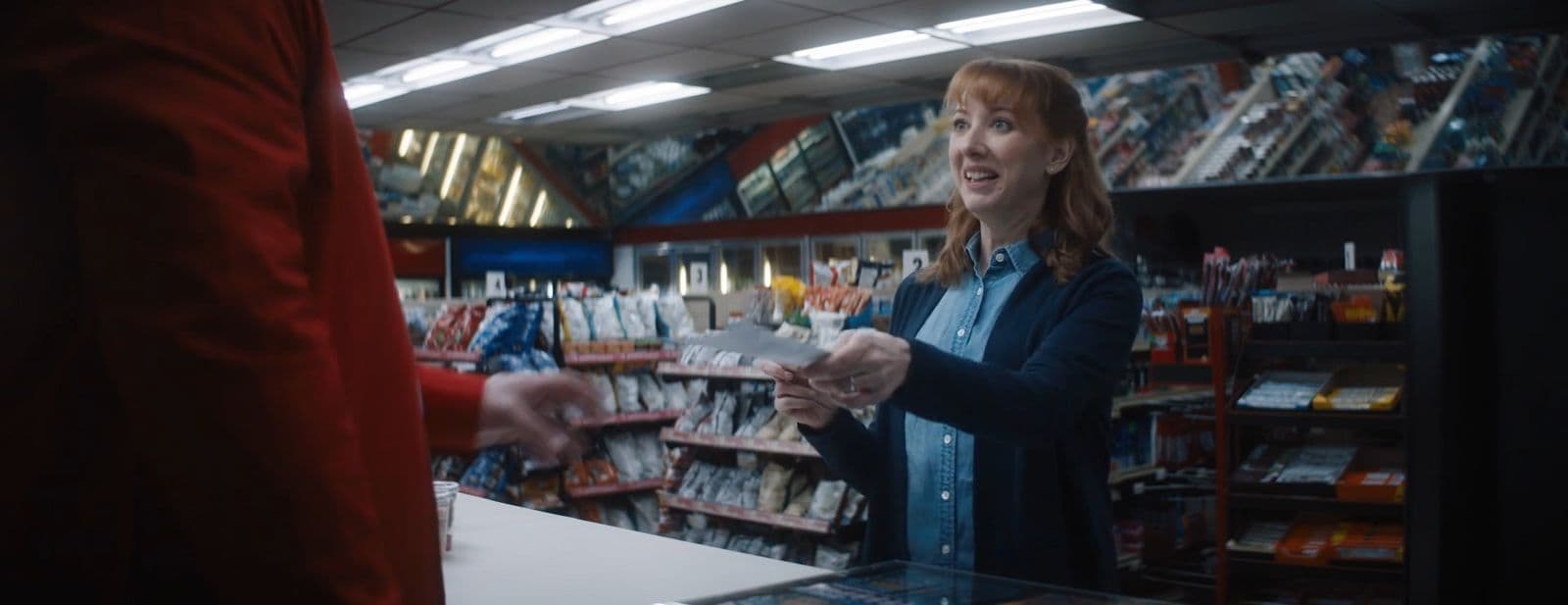 a woman standing in a store talking to a man