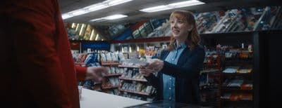 a woman standing in a store talking to a man