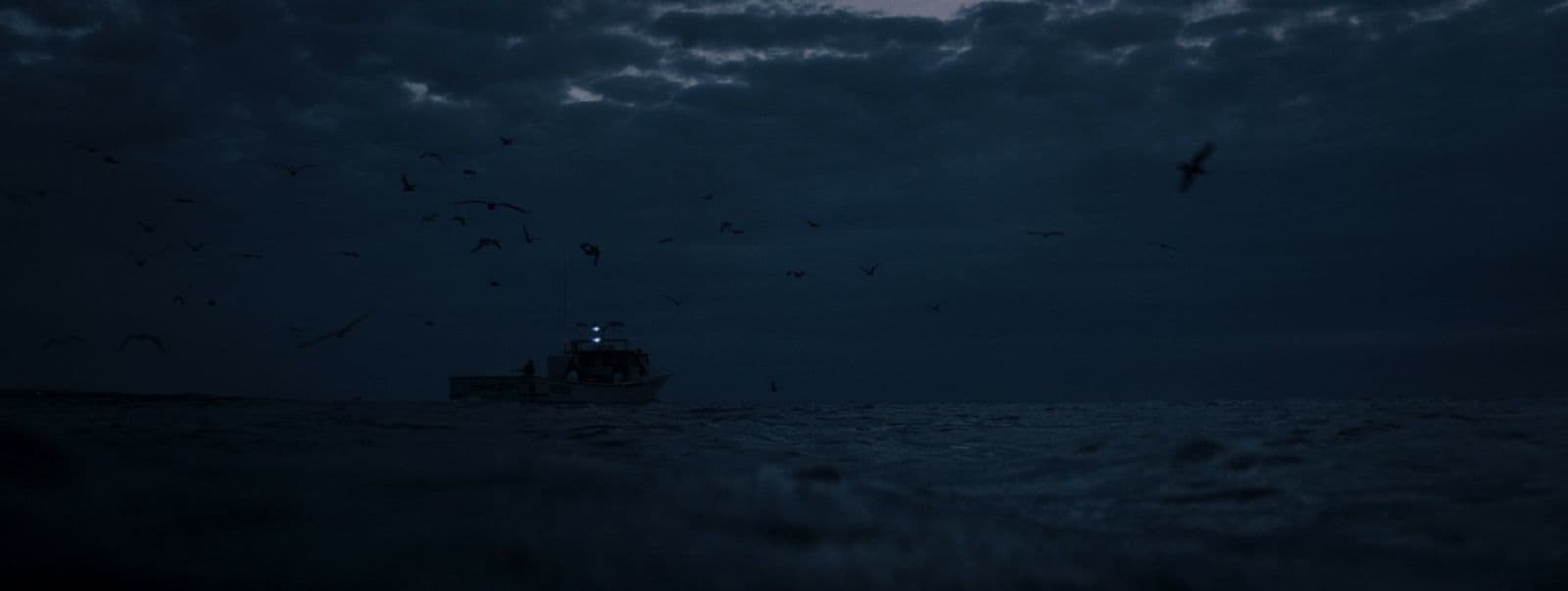 a boat in the middle of the ocean at night