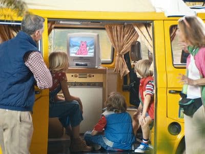 a group of people standing around a yellow van