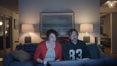 a man and woman sitting on a couch in a living room