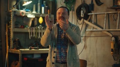 a man standing in a room holding his hands up