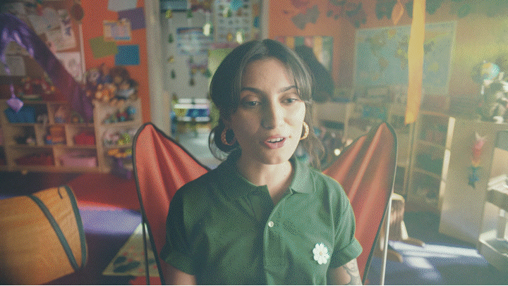 a woman in a green shirt standing in a room