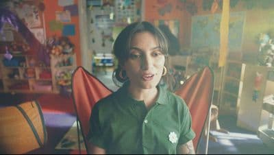 a woman in a green shirt standing in a room